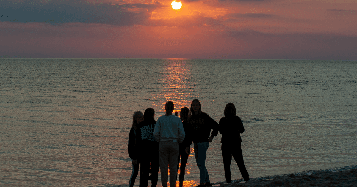Grupo de jóvenes conversando en la playa